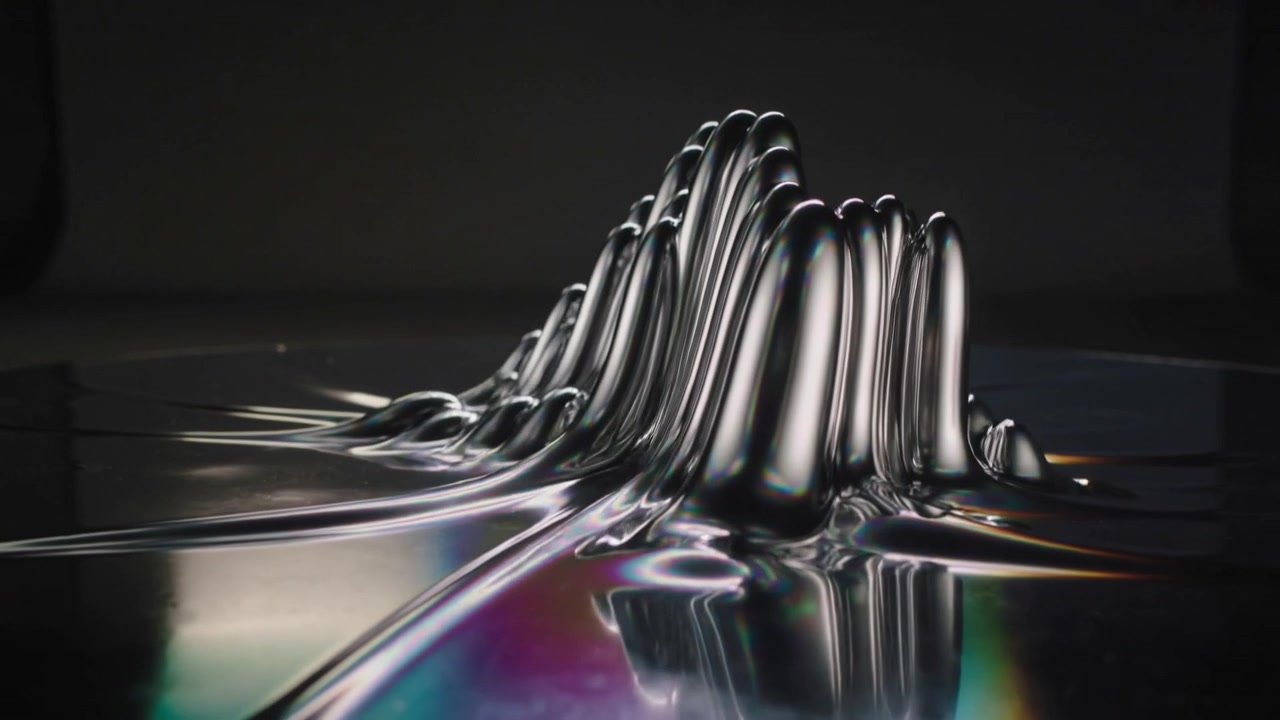 Forming viscous metallic liquid creating spikes and ridges on reflective tray with colored lights