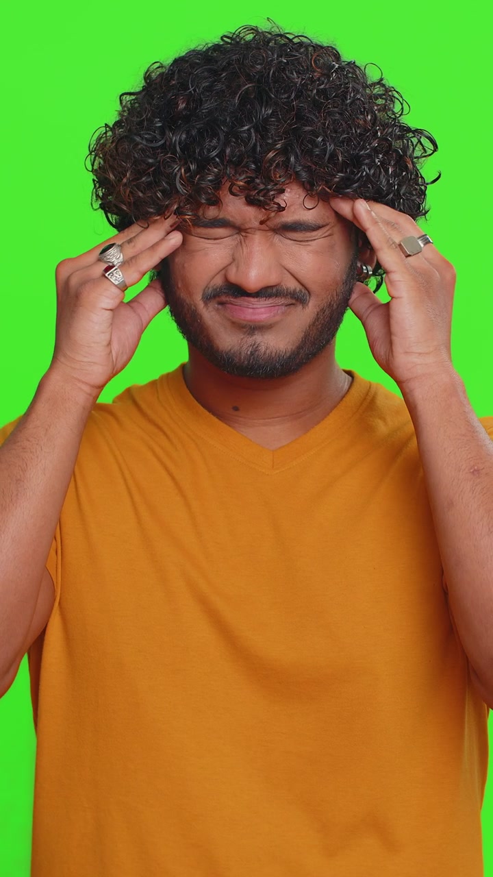 Uomo indiano che massaggia le tempie per curare il problema del mal di testa che soffre di tensione e dolore da stress migaine