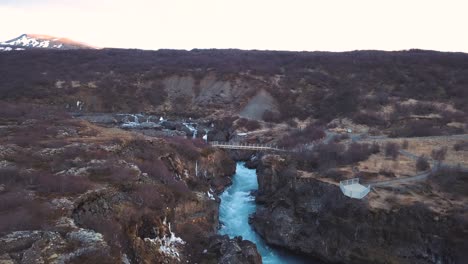 Drone-Con-Movimientos-Cinematográficos-Muestra-Una-Hermosa-Cascada-Islandesa,-Hraunfossar,-A-La-Luz-Del-Atardecer-Desde-Múltiples-ángulos