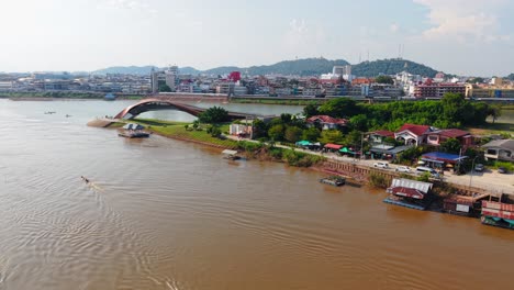 aerial view of a riverfront city with bridge and floating houses
