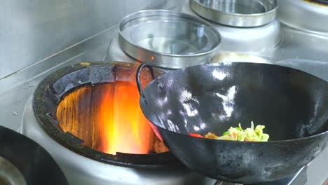 professional chef fires up oil on a pan in a commercial kitchen restaurant