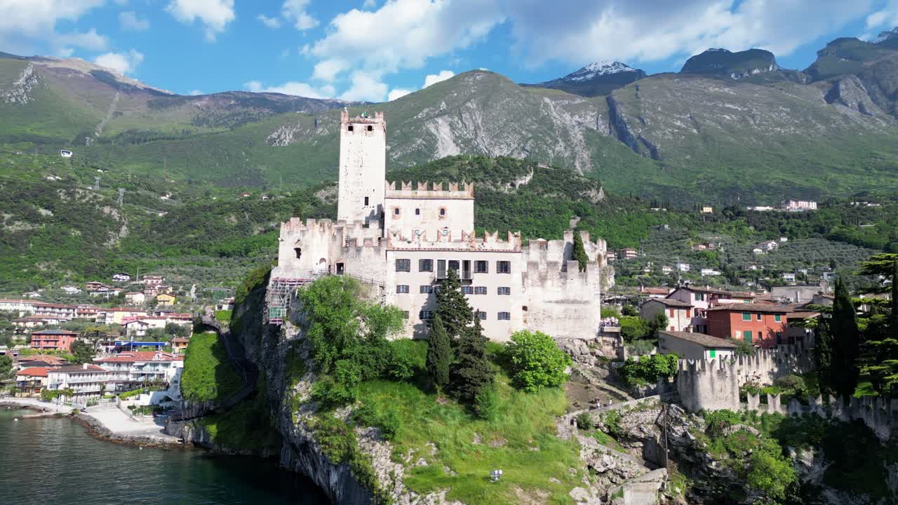 Drone shot of Castello Scaligero atop a rocky cliff above Lake Garda in Malcesine. Malcesine, Italy