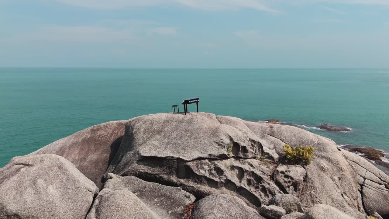 Drone circles lone pianist on Thailand's rocky coast