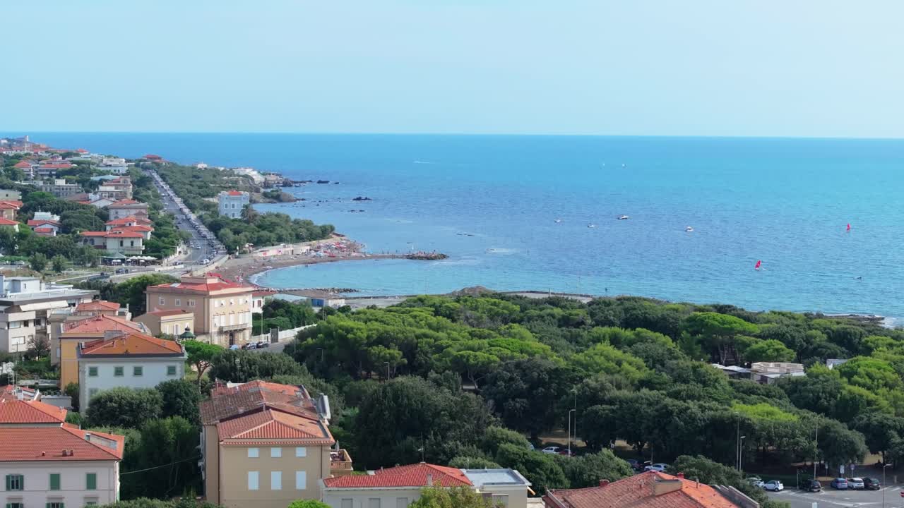 Orbita aerea parziale dalla costa meridionale di Livorno, Italia, verso il mare, dove si praticano windsurf e altre attività ricreative.