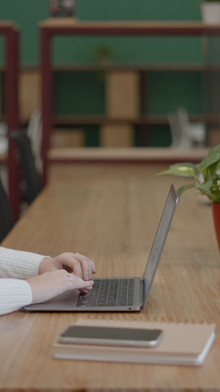 Person Typing on a Laptop in an Office Setting