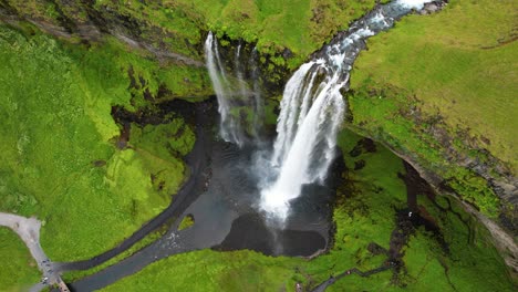 seljalandsfoss waterfall and green meadows in iceland, aerial drone view