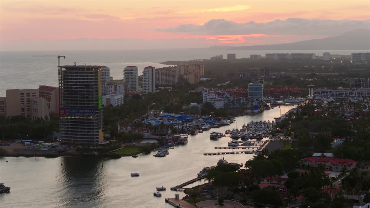High angle shot of Marina Vallarta with yachts, high-rise buildings, and sunset sky in Puerto Vallarta, Mexico