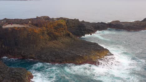 ocean waves crashing against rocky cliffs of blow hole point in kiama, nsw, australia