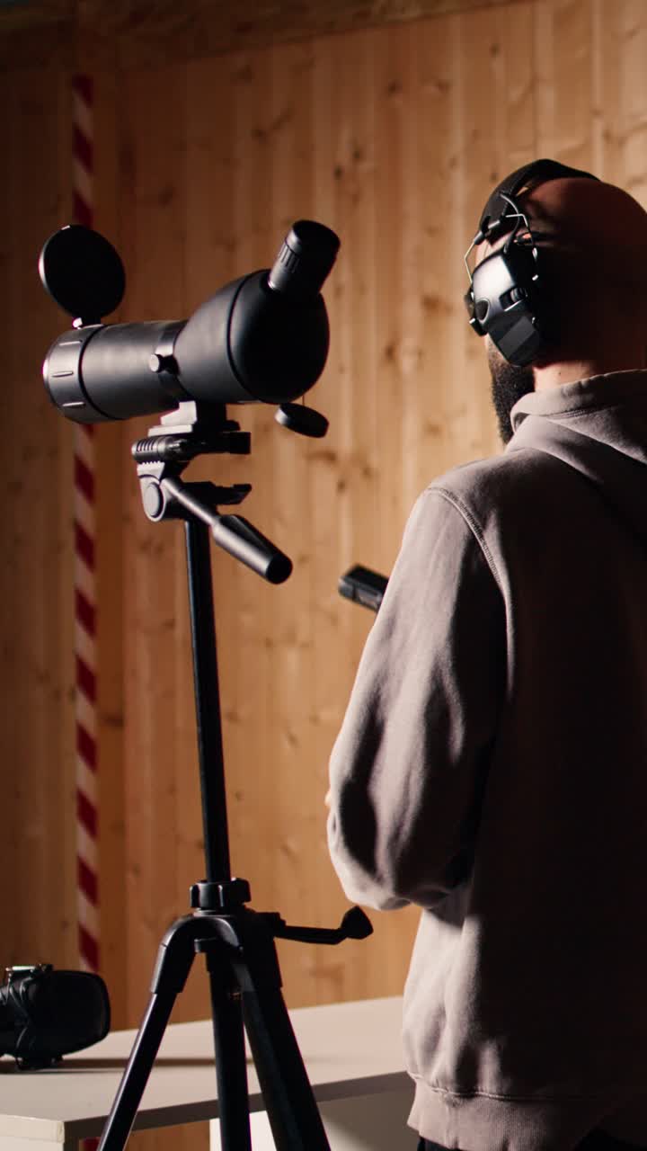 Vertical video Person analyzing targets shot using magnifying lens during firearm practice