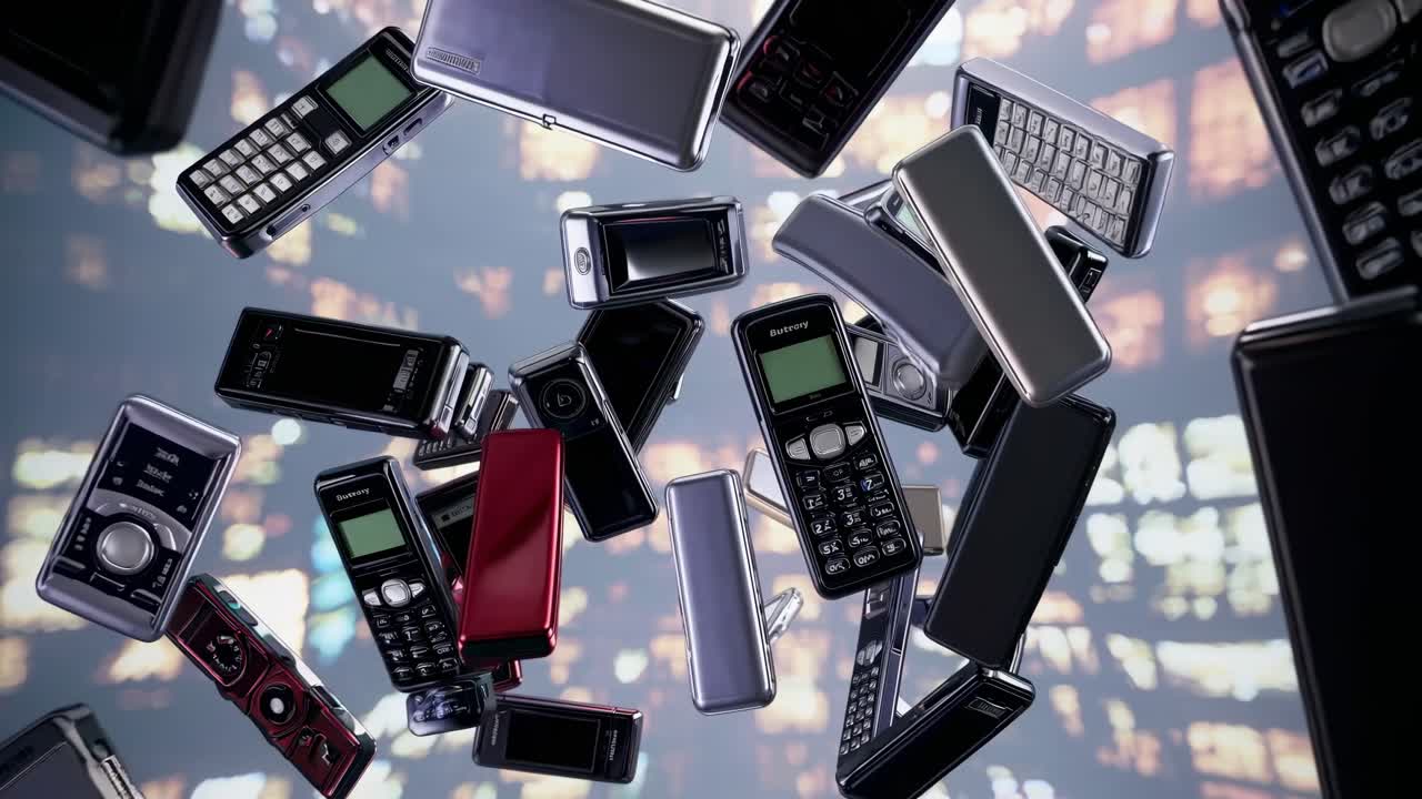 Many old fashioned mobile phones are falling against a blurred background of city lights at night, evoking a sense of nostalgia for past technology and communication