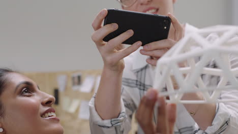 happy business woman engineers using smartphone taking photo of 3d printing geodesic dome model creative colleagues enjoying sharing design ideas in diverse office