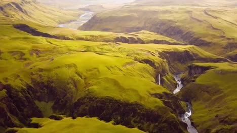 4k drone, aerial cinematic shots of the landscape images below the kirckjufell mountain in iceland with a cascading waterfall in the middle