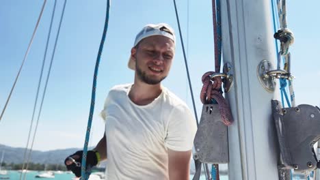 sailor adjusting ropes on boat mast