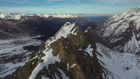 snow-capped rocky mountain peaks of european alps in winter, aerial