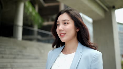 beautiful business woman walking in the corridor between the buildings at downtown. confident women walk towards their goals for success at the city.