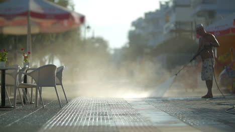 Man-washing-sidewalk-in-the-morning