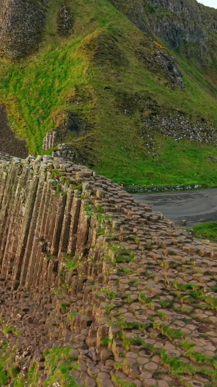 Verticale luchtvideobeelden van de basaltzuilen bij The Giant's Causeway in Bushmills, County Antrim in Noord-Ierland, Verenigd Koninkrijk. Geproduceerd in een verticaal formaat van 1080x1920 met Rec709-kleur.