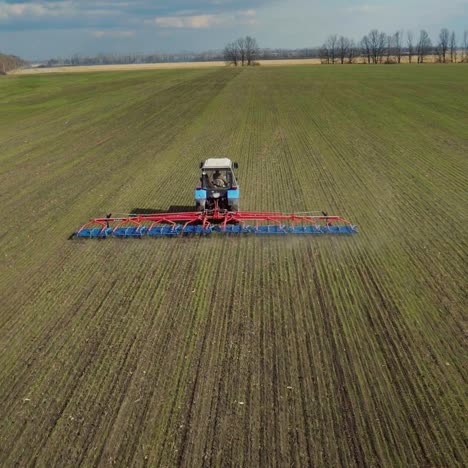 tractor quickly travels across the field cultivates the earth so that moisture does not get lost