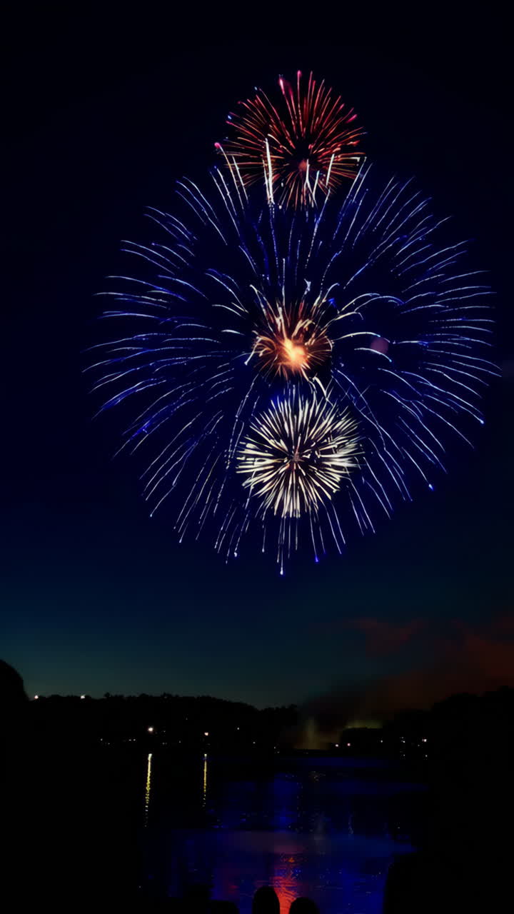 Vibrant Fireworks Exploding Over a Lake at Night with Onlookers