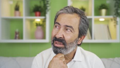 close-up mature man looks at camera confused.