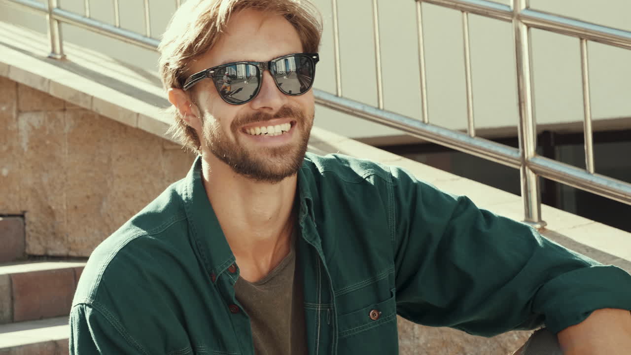 hombre con gafas de sol sentado en los escalones