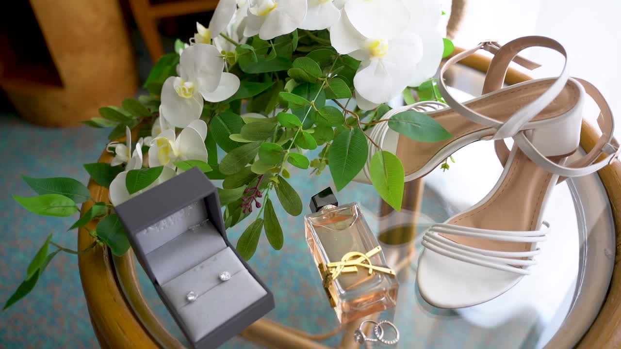 Bride accessories on a round table in front of the window, prepared for the wedding ceremony