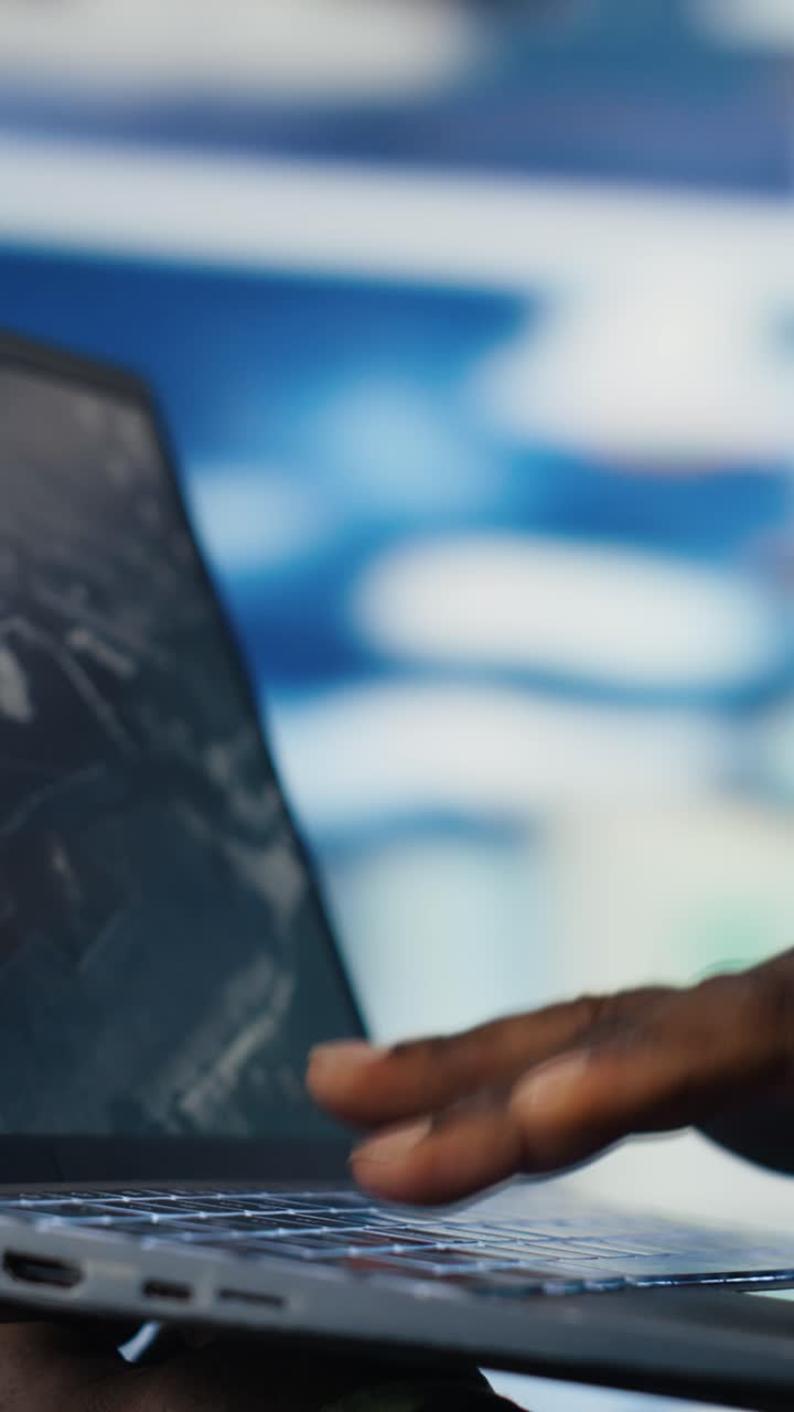 Close-up of Hand Typing on Laptop Keyboard with Map Software