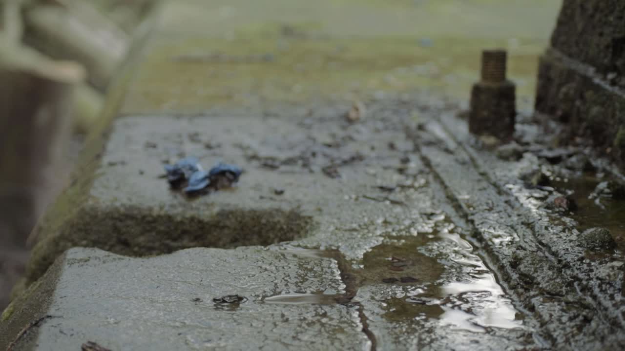 Dirty grunge water leaking onto stone floor of building