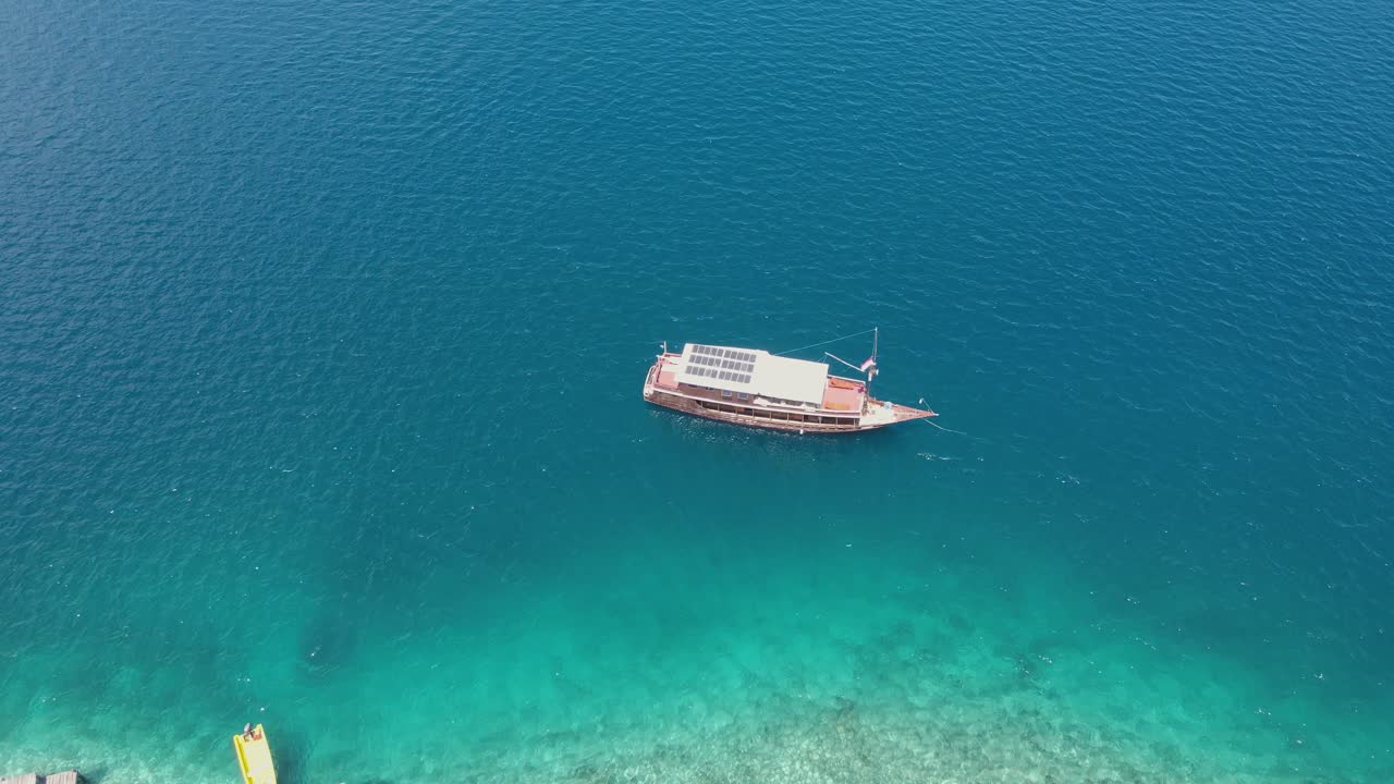 이국적인 백사장 옆에 태양 전지판이 있는 정박된 보트의 조감도
