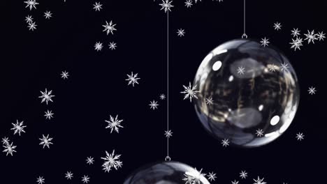 animación de nieve cayendo sobre las bolas de navidad de vidrio sobre fondo negro