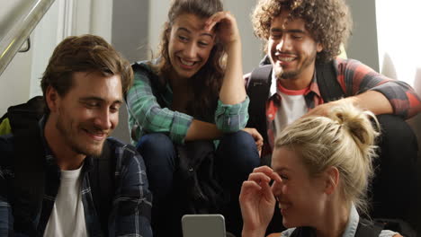 Woman-showing-mobile-phone-to-her-friends