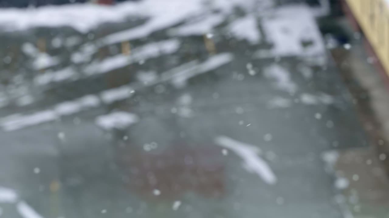 유타의 추운 겨울 눈보라 속에서 배경이 초점이 맞지 않은 채 눈이 휘날리며 천천히 땅으로 떨어지는 느린 동작 삼각대 샷