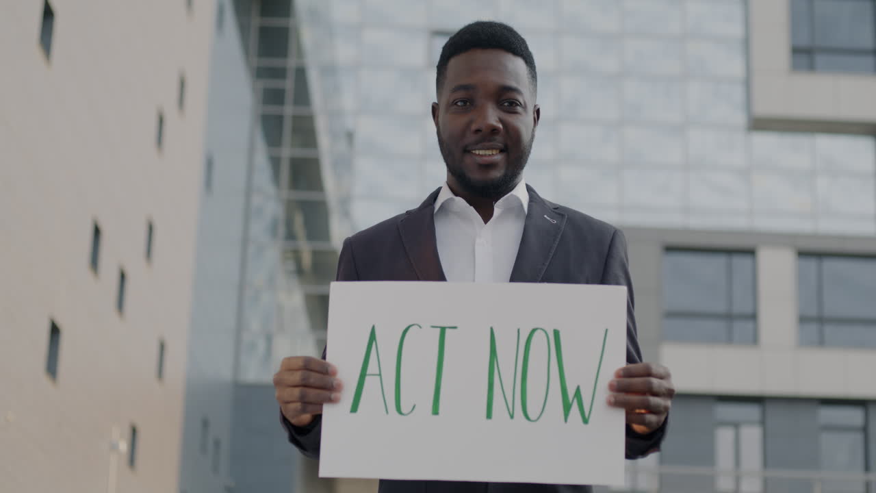 Man Holding Sign Reading "Act Now"