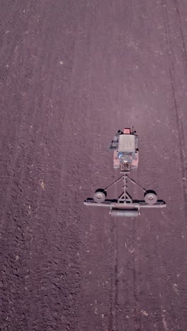 shooting from drone flying over tractor with harrow system