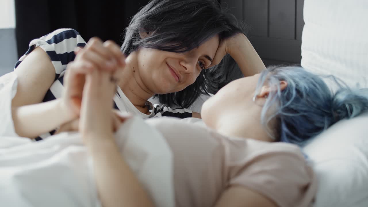 handheld video of happy lesbian couple kissing in the morning.