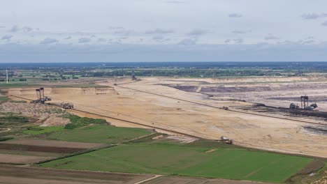 Garzweiler-surface-mine,-open-cut-brown-coal,-lignite,-mine-bordering-green-fields