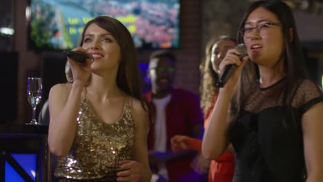 mujer multiétnica cantando en micrófonos