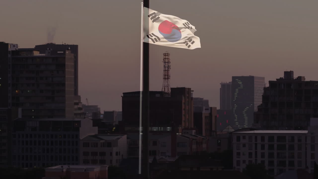 South Korean flag being animated waving over urban skyline at dusk, with flat design style