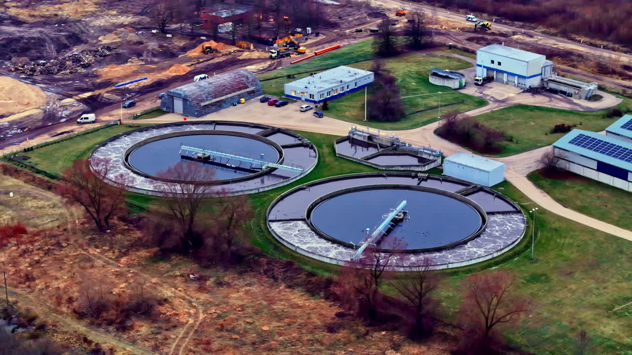 Aerial view of water treatment plant with circular tanks and buildings