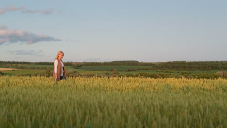 woman farmer walking through a picturesque field of wheat