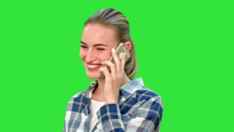mujer bonita con ropa casual hablando por teléfono y sonriendo en una pantalla verde, llave cromada