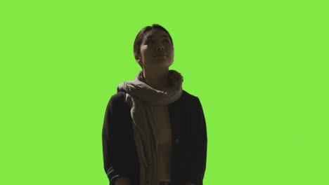 low key studio shot of woman looking all around frame against green screen in vr environment 2