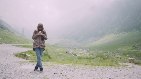 a young woman hiker climbs mountains with photo camera. transfagarasan, carpathian mountains in romania