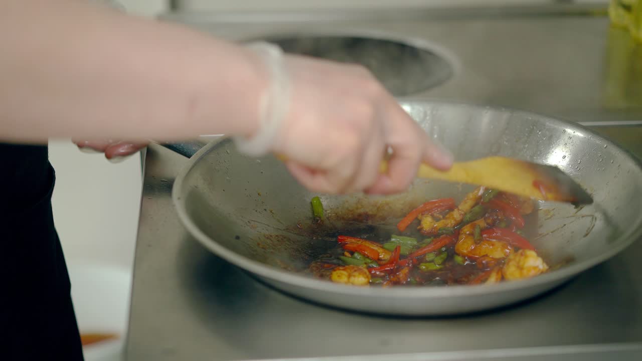 cocinar camarones asados con verduras en una sartén regados con salsa
