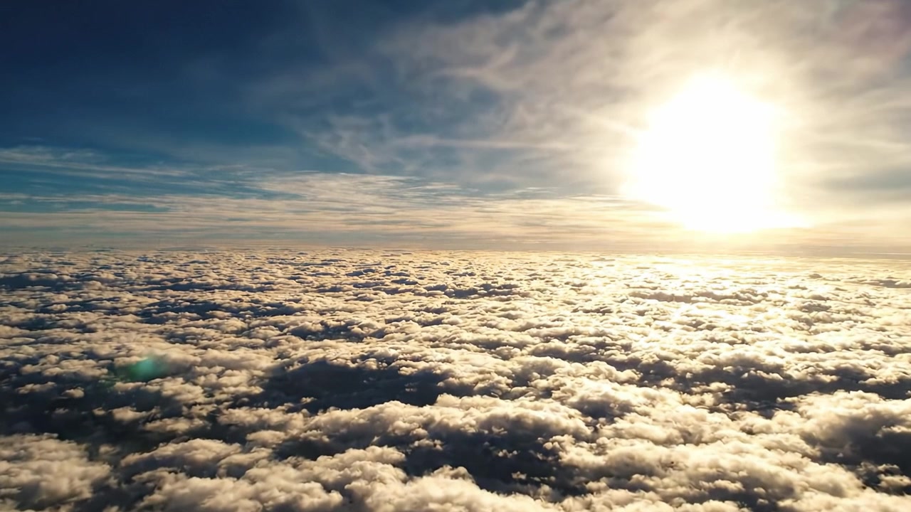 Vista Aerea Mozzafiato di Nuvole Soffici e Vaporose Baciate dalla Luce Dorata del Sole, che Mostra la Tranquillità e la Bellezza del Cielo Sopra la Superficie Terrestre.