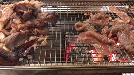 Traditional-Korean-BBQ-beef-bulgogi-and-pork-belly-are-grilled-on-an-open-charcoal-grill-table-side-at-a-restaurant