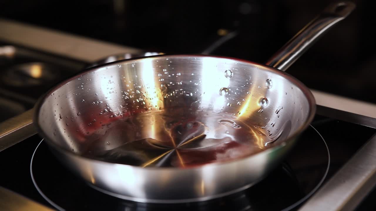 Pouring Water into a Stainless Steel Frying Pan