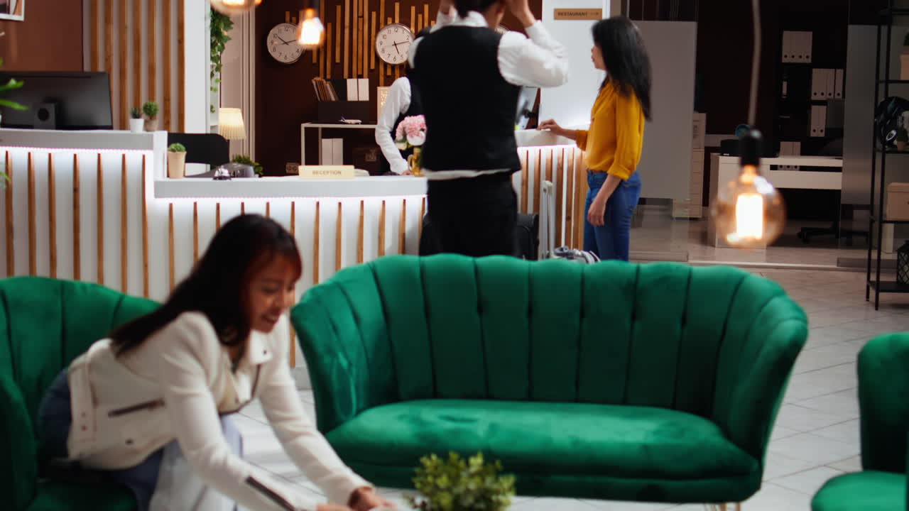 아시아인 손님이 호텔 서비스와 시설에 대해 직원에게 물어보고 있습니다.