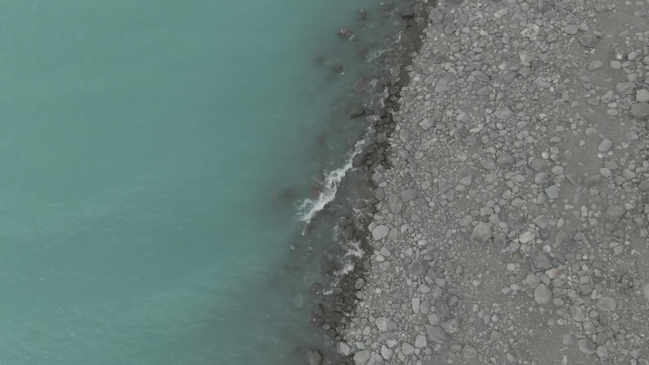 rising up drone shot of lake pukaki showing the beach and the lake
