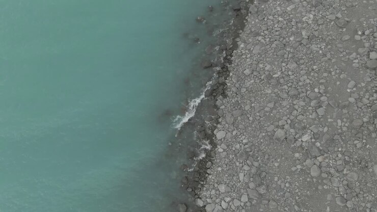 rising up drone shot of lake pukaki showing the beach and the lake